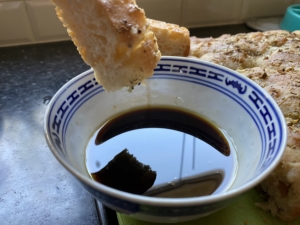 Dipping sourdough focaccia in olive oil and balsamic vinegar